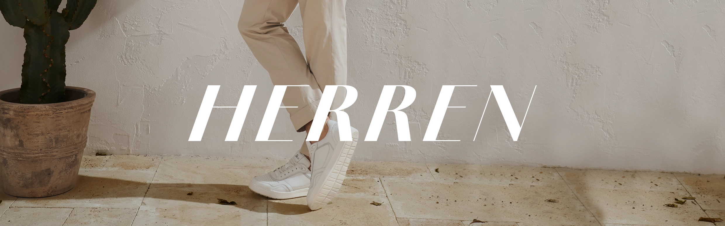 Herrenschuhe - weiße Sneaker lässig getragen von einem Mann