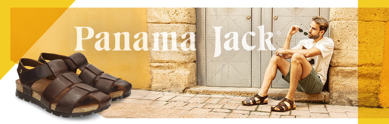 Mann sitzt vor eine Tür und trägt Panama Jack Sandalen